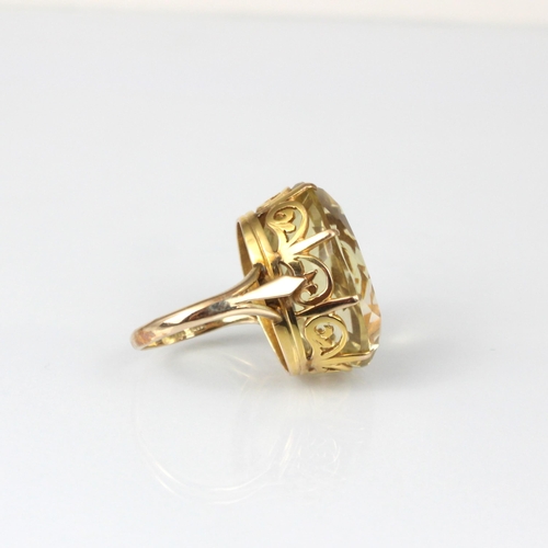 335 - A citrine cocktail ring, the oval cut stone within claw setting edge leading to plain polished shank... 