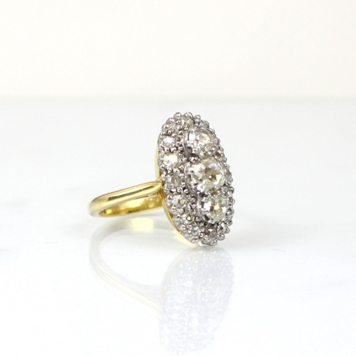 343 - An Edwardian style diamond cluster ring, the three graduated old cut diamond centre within surround ... 