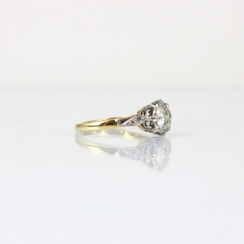 347 - An Edwardian style diamond solitaire, the central round cut diamond within stylised white metal illu... 