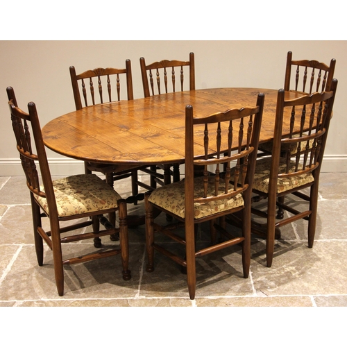 1017 - A Georgian style honey oak pedestal dining table and six conforming spindle back chairs, late 20th c... 