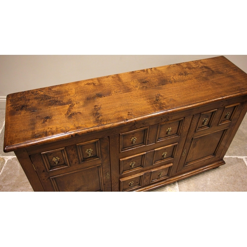 1018 - A 17th century style honey oak sideboard, late 20th century, the rectangular moulded top over three ... 