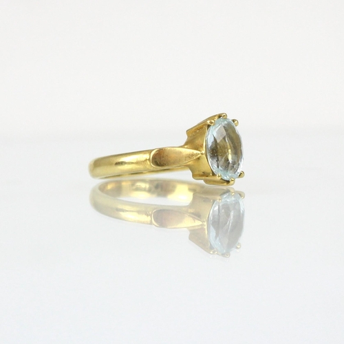 268 - A bespoke untested aquamarine ring, the oval cut stone within yellow metal claw setting edge leading... 