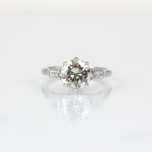 275 - A mid 20th century diamond solitaire ring, the central round cut diamond set in 18ct white gold  cla... 