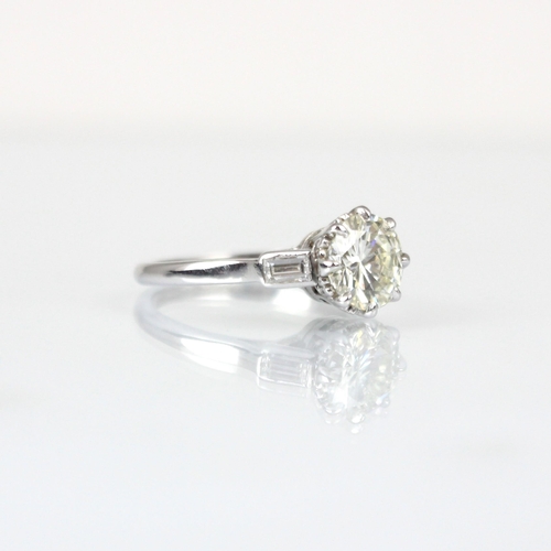 275 - A mid 20th century diamond solitaire ring, the central round cut diamond set in 18ct white gold  cla... 