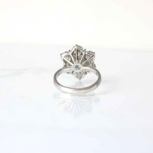 277 - A mid 20th century diamond cluster ring, the round cut diamond within floral surround of six round c... 