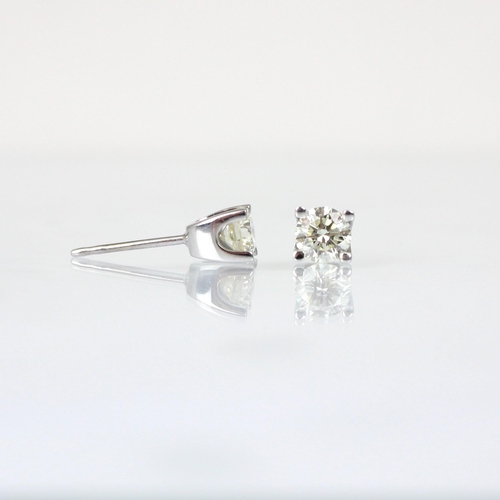 283 - A pair of certified diamond stud earrings, the round cut diamonds four claw set in white metal, with... 