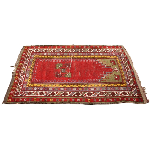 805 - A Turkish hand knotted village rug, the central vibrant red field with a stylised leaf motif enclose... 