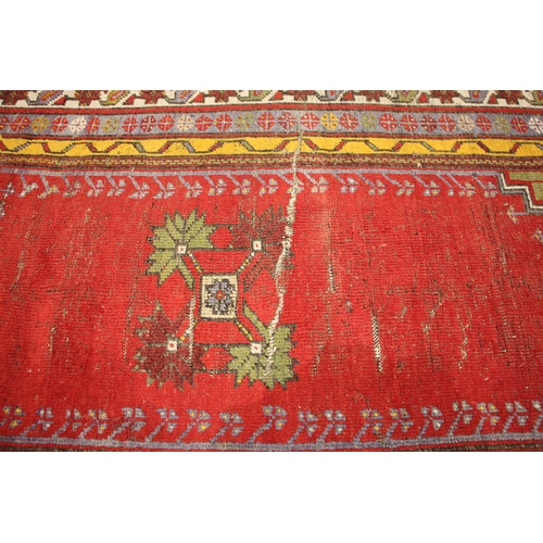 805 - A Turkish hand knotted village rug, the central vibrant red field with a stylised leaf motif enclose... 