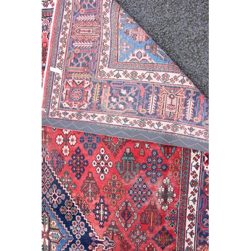 812 - A fine hand woven washed red ground Persian Joshagan carpet, in red, blue and ivory colourways, the ... 