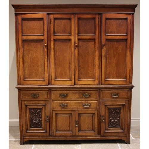 941 - A late 19th century oak housekeepers cupboard, the moulded cornice over four panelled doors, upon th... 