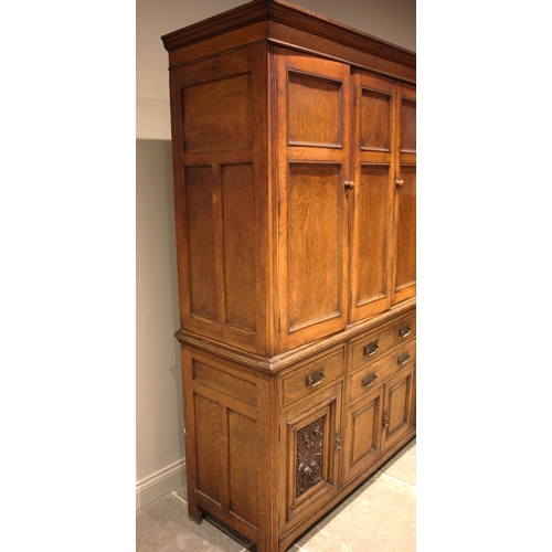 941 - A late 19th century oak housekeepers cupboard, the moulded cornice over four panelled doors, upon th... 