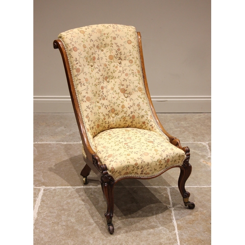 948 - A Victorian rosewood framed low seat slipper chair, later re-covered in foliate fabric, the swept fr... 