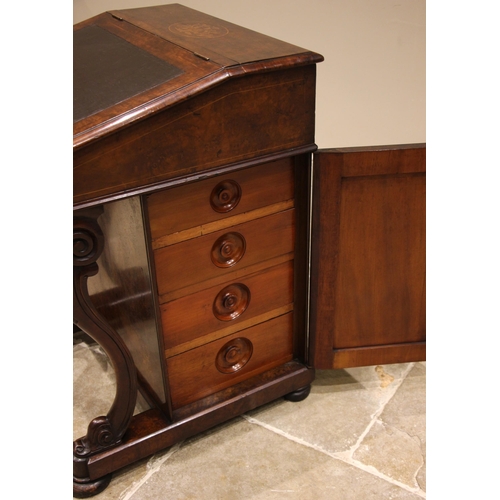 955 - A Victorian figured walnut davenport, the hinged cover centred with an inlaid marquetry oval opening... 