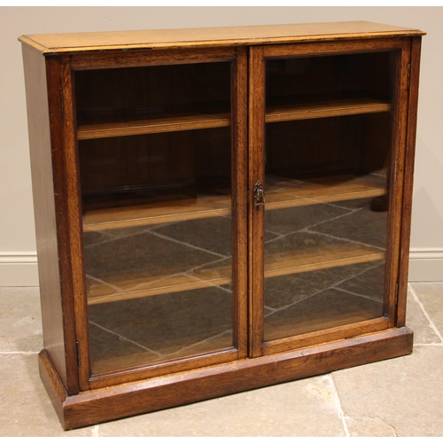 958 - A Victorian golden oak glazed oak bookcase, the moulded top over a pair of glazed doors opening to t... 