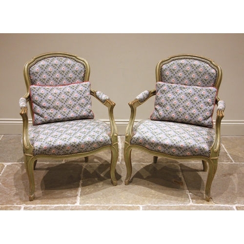 986 - A pair of painted French fauteuil, early 20th century, later re-covered in lattice pattern floral ta... 