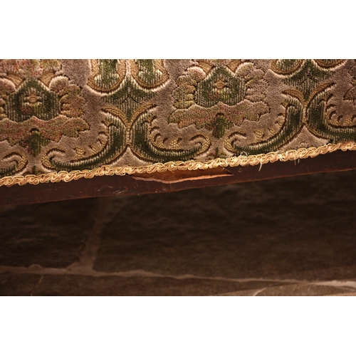 994 - An Edwardian mahogany sofa, in embossed foliate fabric, the padded scroll back rest and arms upon su... 