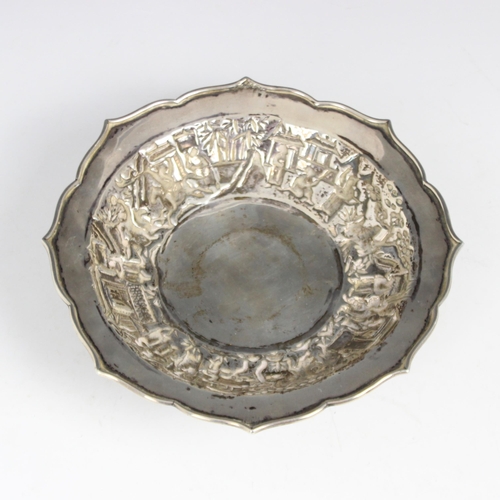 23 - A Chinese white metal comport, Wang Hing, the shaped rim above embossed bowl depicting figures among... 