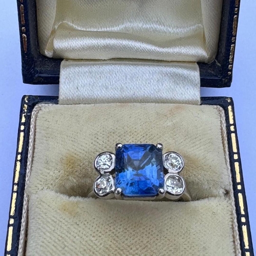 351 - A mid 20th century diamond and sapphire ring, the emerald cut sapphire claw set in white metal, with... 