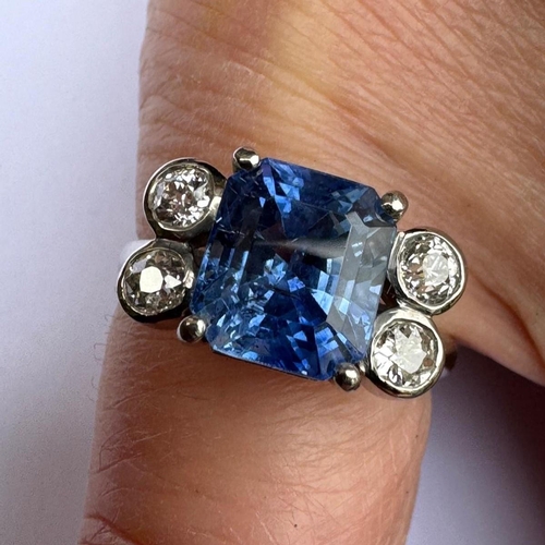 351 - A mid 20th century diamond and sapphire ring, the emerald cut sapphire claw set in white metal, with... 