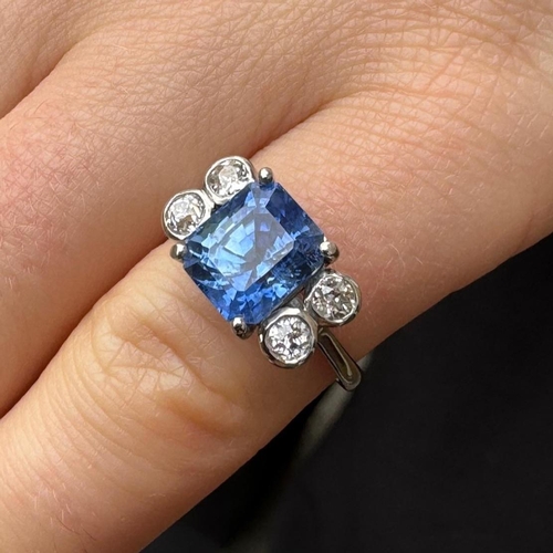 351 - A mid 20th century diamond and sapphire ring, the emerald cut sapphire claw set in white metal, with... 