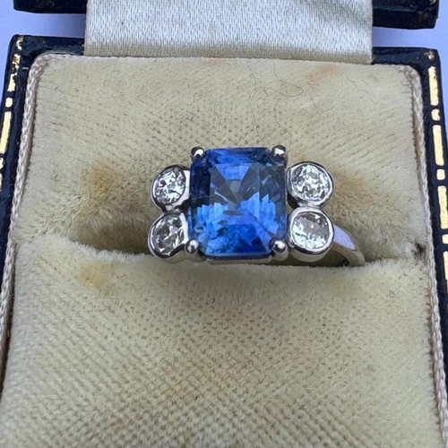 351 - A mid 20th century diamond and sapphire ring, the emerald cut sapphire claw set in white metal, with... 