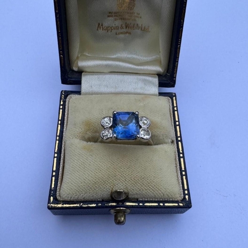 351 - A mid 20th century diamond and sapphire ring, the emerald cut sapphire claw set in white metal, with... 