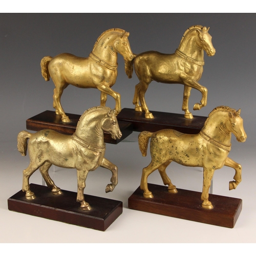 506 - The Horses of St. Mark, a set of four gold painted spelter horses, 20th century, each modelled on a ... 