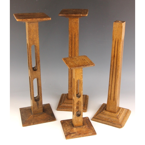 651 - Four oak milliners hat stands, early 20th century, to include two square section openwork examples u... 