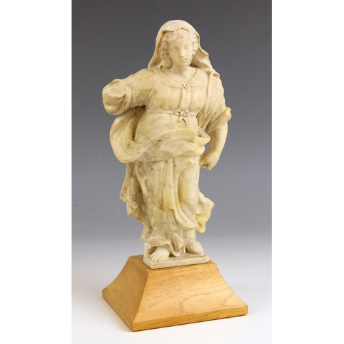 524 - A carved limestone figure modelled as a classical maiden, raised on a shaped oak plinth, 28cm high