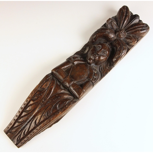 525 - A carved oak term, possibly 17th century, carved as a figure, arms crossed below a relief carved flo... 