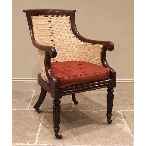 979 - A Victorian mahogany bergere library chair, the concave back rest extending to down swept arms and s... 