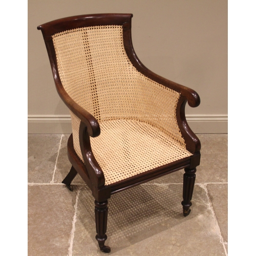 979 - A Victorian mahogany bergere library chair, the concave back rest extending to down swept arms and s... 