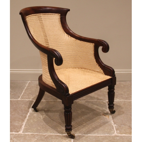 980 - A Victorian mahogany bergere library chair, the concave back rest extending to down swept arms and s... 