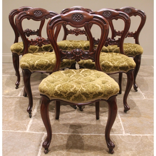 982 - A set of six Victorian mahogany framed dining chairs, each with a carved buckle back above a button ... 