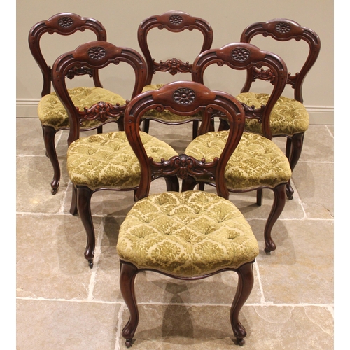 982 - A set of six Victorian mahogany framed dining chairs, each with a carved buckle back above a button ... 