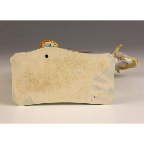 606 - An English pottery cow creamer and cover, circa 1810, on a wafer-thin base with maid, in a Pratt war... 