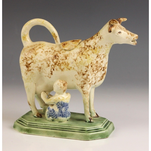 605 - An English pottery cow creamer and cover, circa 1800, Yorkshire or Staffordshire, on a canted and st... 