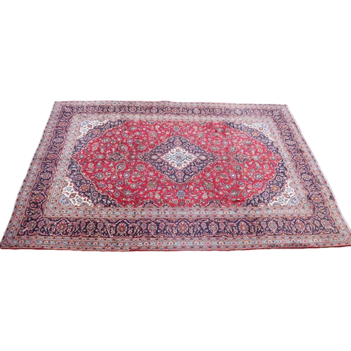 806 - A full wool pile hand woven Persian Kashan carpet, the rich red ground central field with a graduate... 