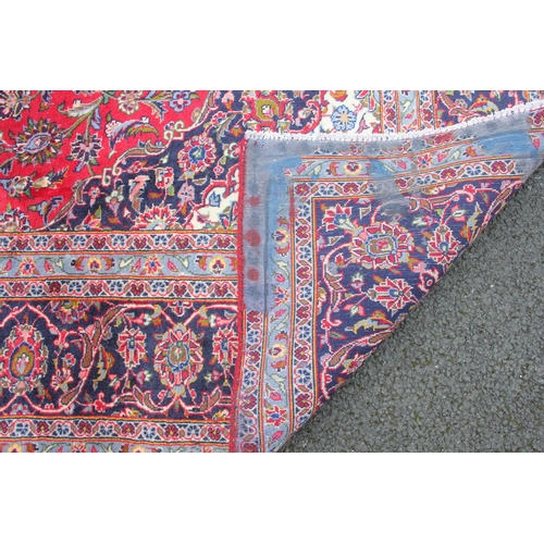 806 - A full wool pile hand woven Persian Kashan carpet, the rich red ground central field with a graduate... 