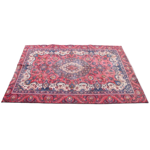 807 - A vintage Persian Tabriz carpet, in red, blue and ivory colourways, with a traditional medallion des... 