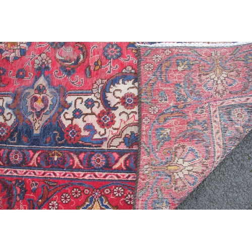 807 - A vintage Persian Tabriz carpet, in red, blue and ivory colourways, with a traditional medallion des... 