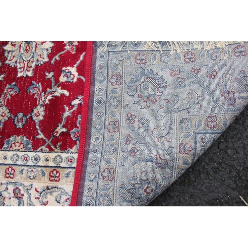 811 - A red ground full pile Kashmir rug, with an all over Ziegler floral design, 170cm x 120cm