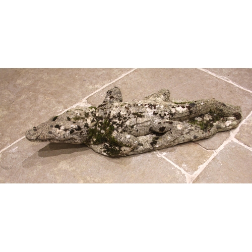 517 - A reconstituted stone model of a crocodile, 20th century, in weathered condition, 86cm long