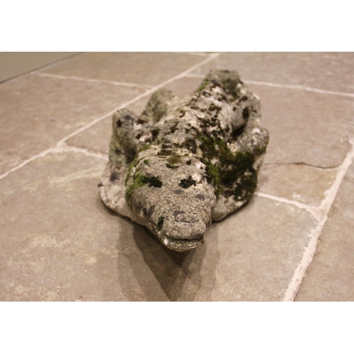 517 - A reconstituted stone model of a crocodile, 20th century, in weathered condition, 86cm long