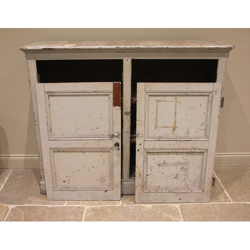 973 - A Victorian painted pine cupboard, the pair of panelled doors opening to twin compartments, each wit... 