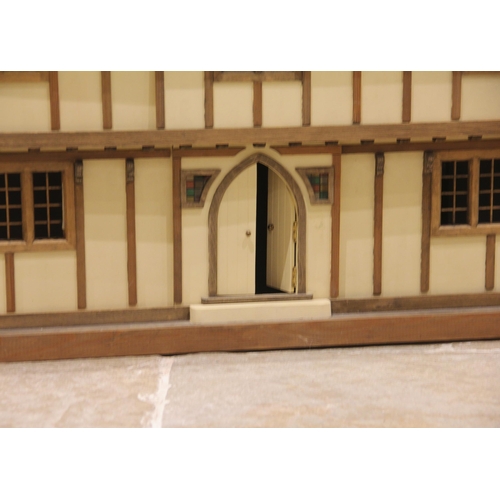 676 - A scratch built mock Tudor dolls house, the removable front panel and hinged roof opening to an arra... 