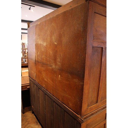 941 - A late 19th century oak housekeepers cupboard, the moulded cornice over four panelled doors, upon th... 