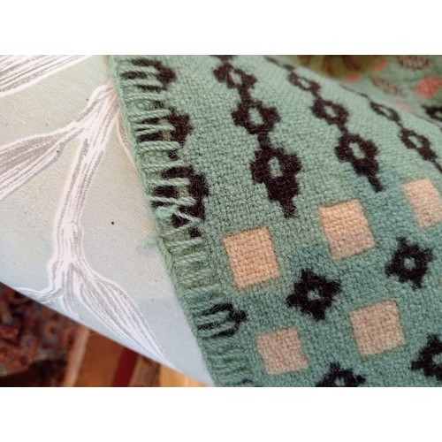 647 - A woollen Welsh blanket, in sage green, pink and oatmeal colourways, with a traditional geometric an... 