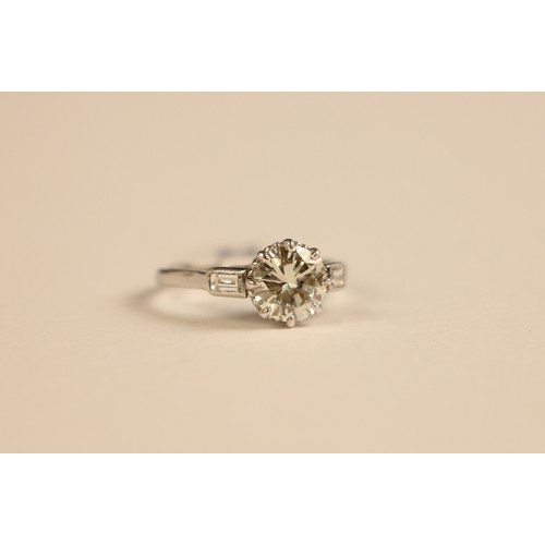 275 - A mid 20th century diamond solitaire ring, the central round cut diamond set in 18ct white gold  cla... 