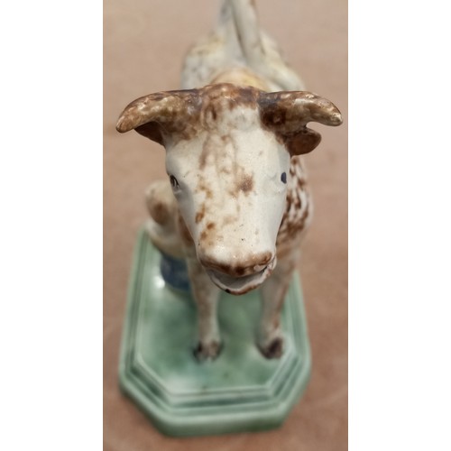 605 - An English pottery cow creamer and cover, circa 1800, Yorkshire or Staffordshire, on a canted and st... 